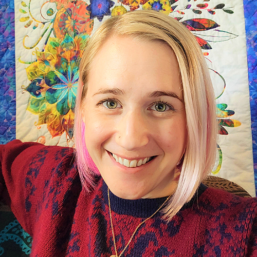 Diana Stumpf Smiling Caucasian female with blonde hair and pink highlights.