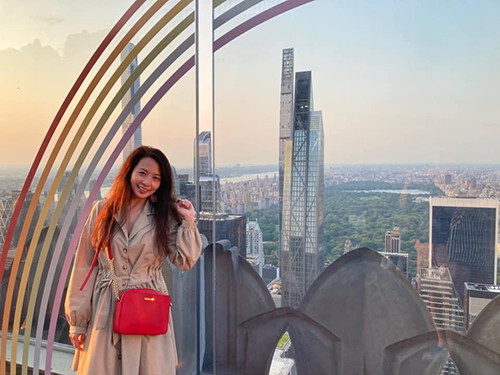 Juyeon Schulman Asian female standing atop a skyscraper in New York City with Central Park in the background.